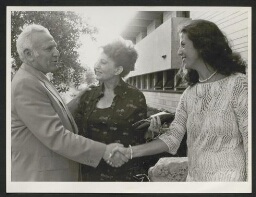 Photographie d'un homme aux cheveux blancs serrant la main à deux femmes élégantes, datée du 25 mai 1978