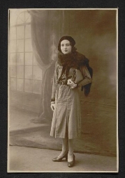 Photographie d'une jeune femme coiffée d'un béret, portant une fourure au cou et son sac à main sous le bras, datée du 17 janvier 1932