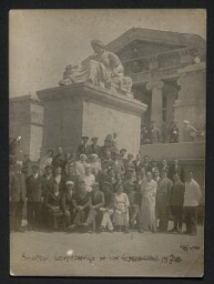Photographie d'un groupe de personnes posant au pied d'une statue, datée de l'année 1940