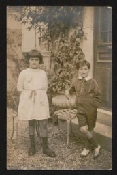 Photographie de deux jeunes enfants, debout, devant le perron, non datée