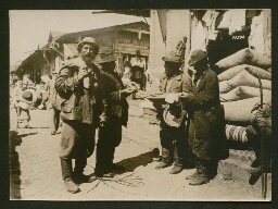 Un commerçant juif vend des tissus à un client portant un baluchon (non datée, vers 1918)