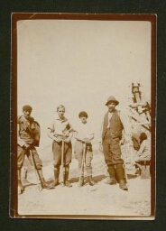 Photographie de trois hommes et une femmes avec des pioches
