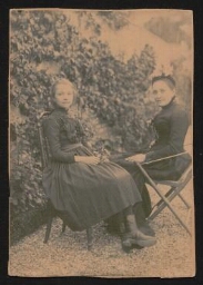 Photographie d'une femme et d'une jeune fille, assises l'une face à l'autre, non datée