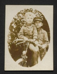 Photographie de jeunes garçons contre une bicyclette, non datée