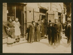 Juifs pieux dans la rue et deux femmes adossées à une porte