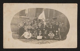 Photographie d'une promotion de jeunes hommes posant devant un drapeau et un panneau avec l'étoile de David, non datée
