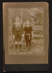 Photographie de deux jeunes enfants, debout, dans un jardin, datée de l'année 1917