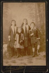 Photographie de quatre jeunes enfants, en tenue élégante, non datée