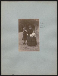 Série de photographies de la famille Naquet - Photographie d'une femme en robe noire assise, un bébé dans les bras, une petite fille à ses côtés (14 juillet 1879 ou 1880)
