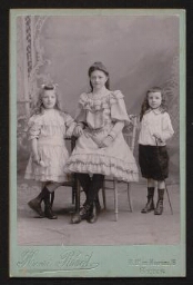 Photographie d'une jeune fille et de deux jeunes enfants, en tenue élégante, datée du 14 juillet 1906